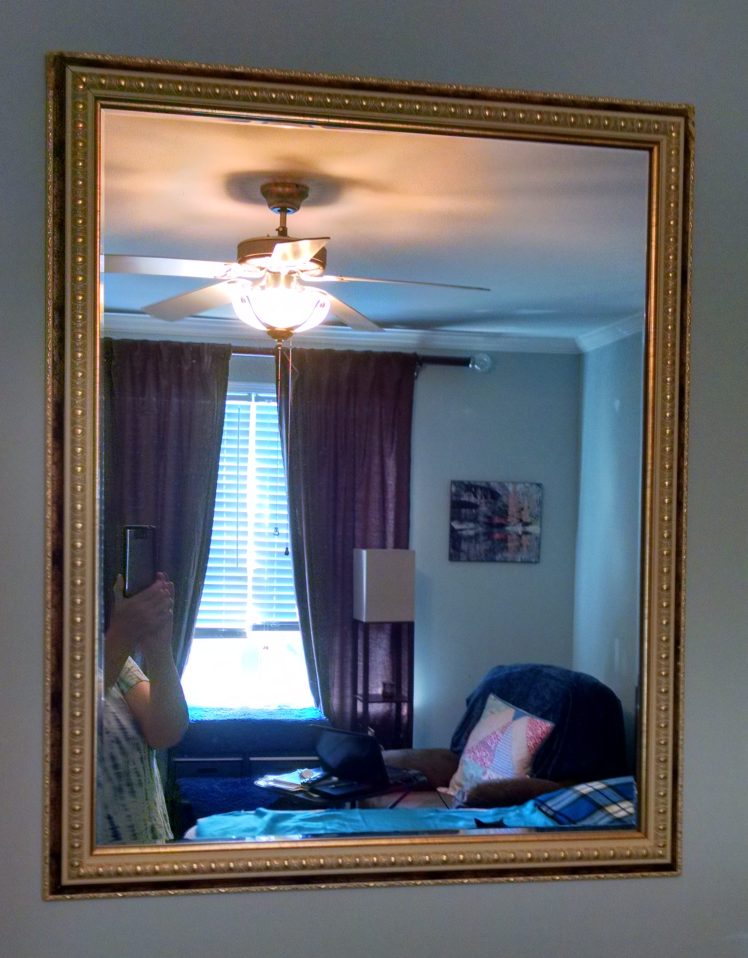 Mirror in the bedroom, reflecting the light of the window.