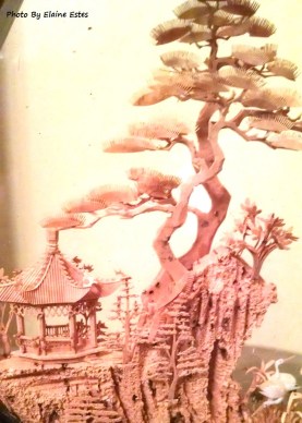Cork wood carving of bonsai trees on a mountain top.