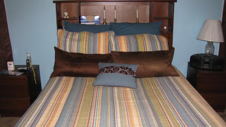 My bed with headboard and shelves.